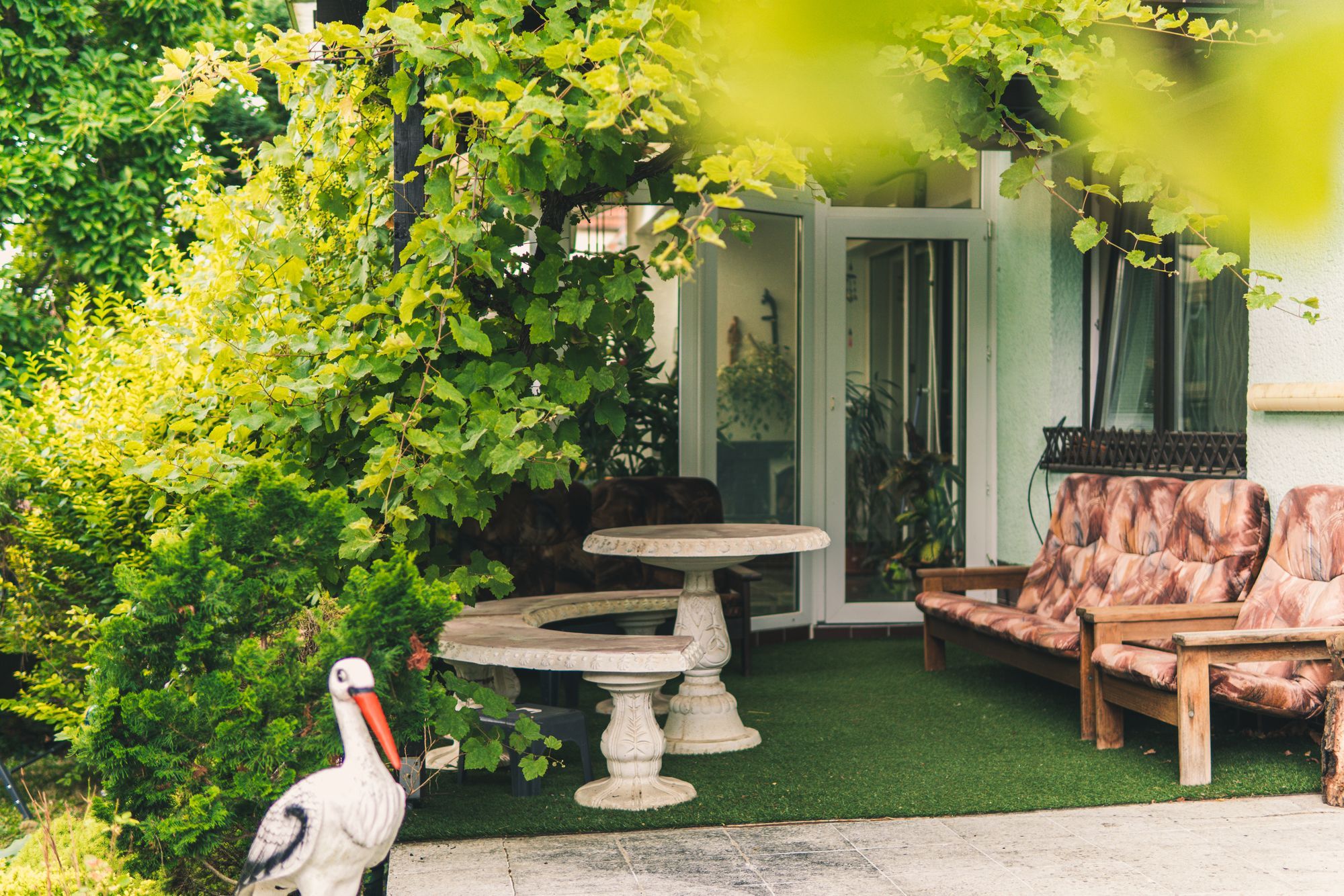 Pergola s vinnou révou a posezením na zahradě